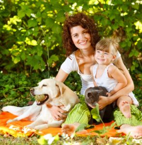 Beautiful mother and daughter relaxing in nature with pets